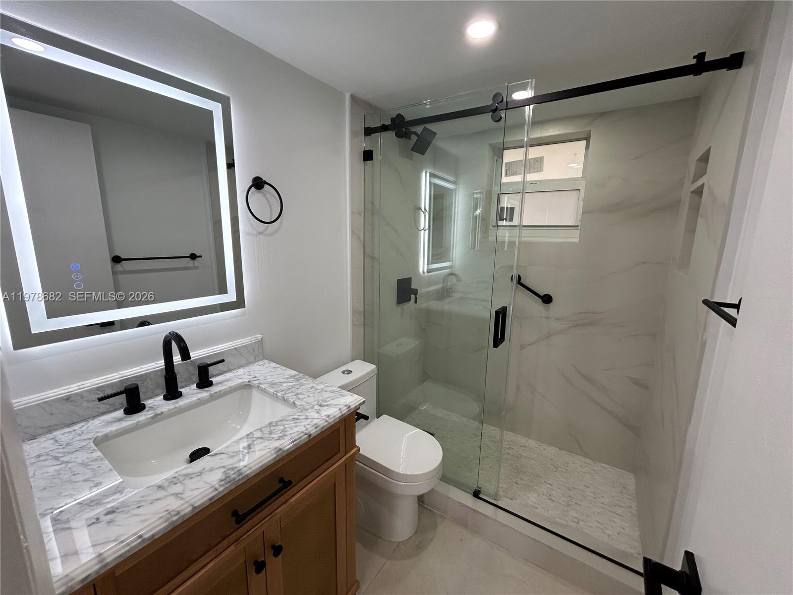 300 Berkley Road, Unit 108 Hollywood, FL 33024 - Photo 24 of 41 a bathroom with a granite countertop sink toilet a mirror a vanity and shower