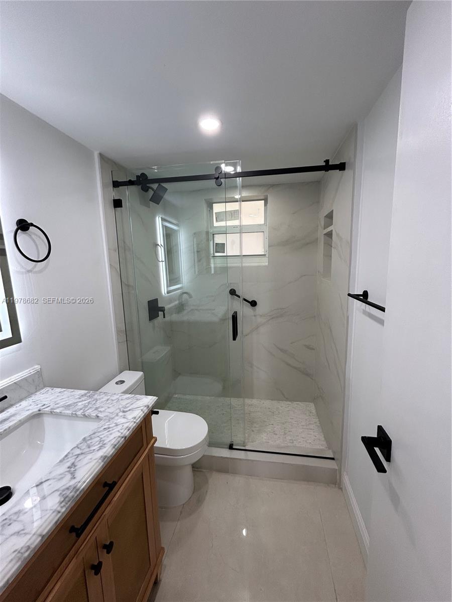 300 Berkley Road, Unit 108 Hollywood, FL 33024 - Photo 25 of 41 a bathroom with a granite countertop sink a toilet and shower