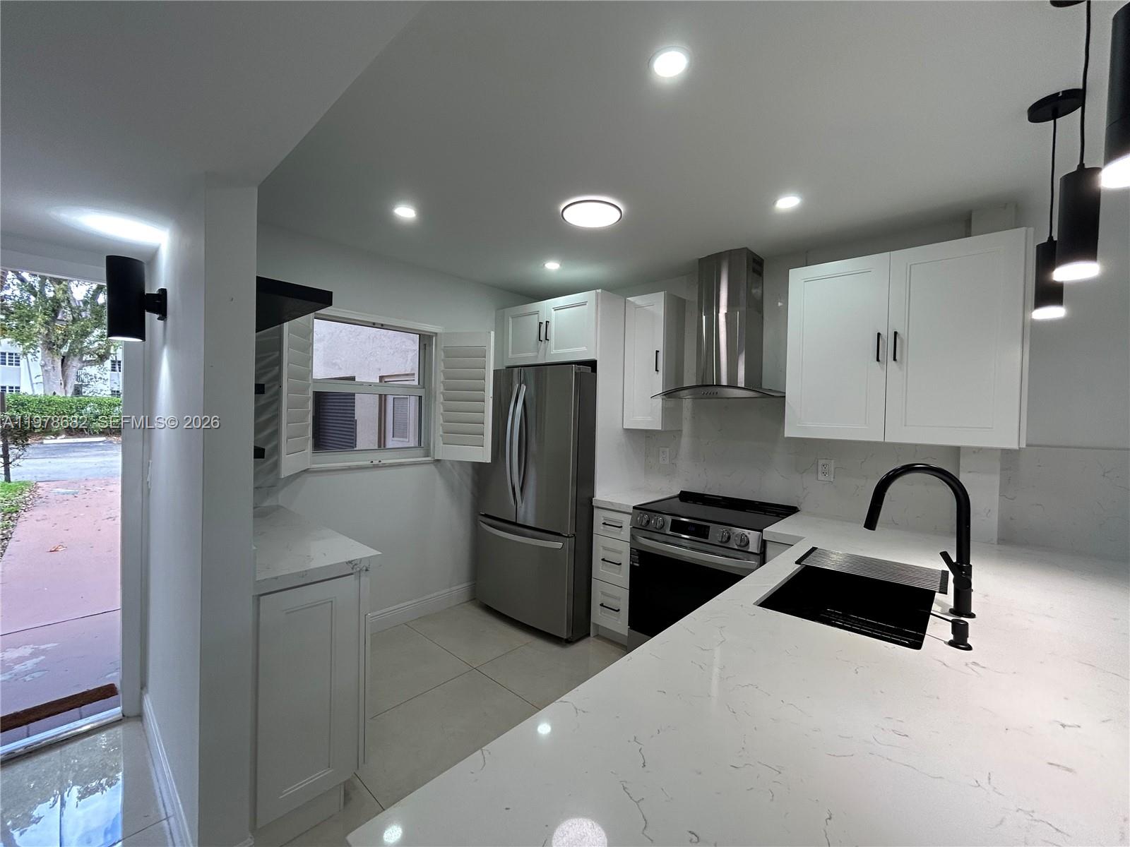 300 Berkley Road, Unit 108 Hollywood, FL 33024 - Photo 8 of 41 a kitchen with refrigerator and sink