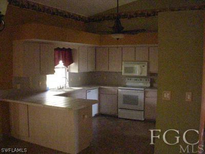 7585 Garry Road Fort Myers, FL 33967 - Photo 5 of 5 a kitchen with kitchen island a stove a sink and a microwave