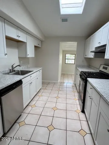 a kitchen with stainless steel appliances granite countertop a sink stove and cabinets