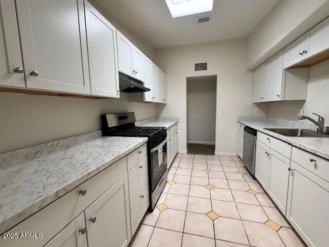 a kitchen with a sink a stove and cabinets