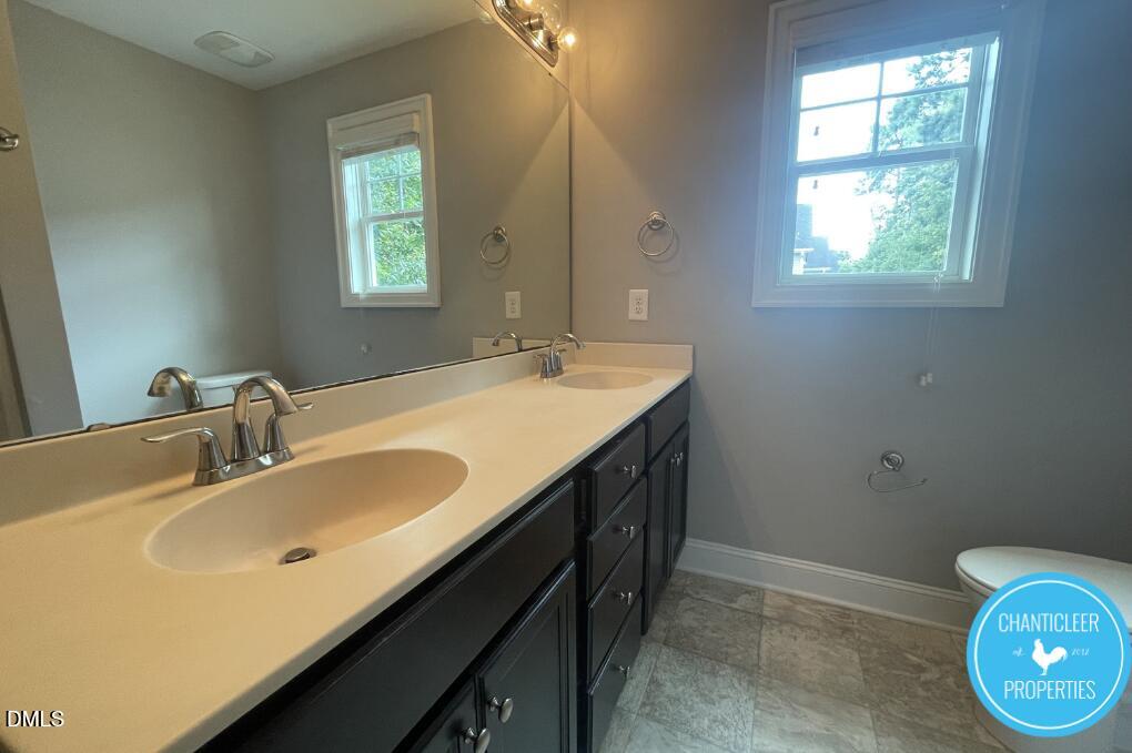 911 Chaney Road, Unit 100 Raleigh, NC 27606 - Photo 13 of 19 a bathroom with a sink vanity and a mirror