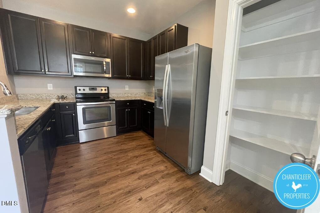 911 Chaney Road, Unit 100 Raleigh, NC 27606 - Photo 4 of 19 a kitchen with stainless steel appliances granite countertop a refrigerator stove and microwave