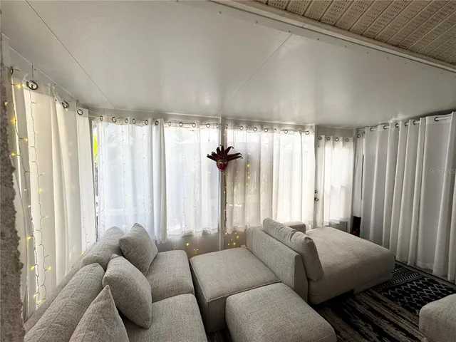 a living room filled with furniture and floor to ceiling window