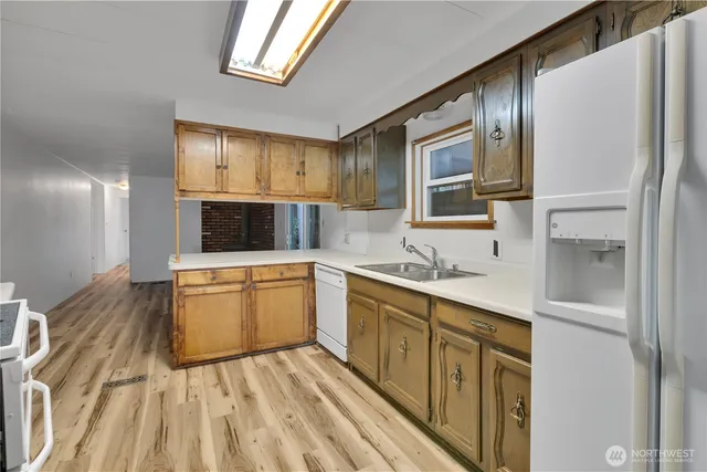 a kitchen with stainless steel appliances granite countertop a sink and wooden cabinets