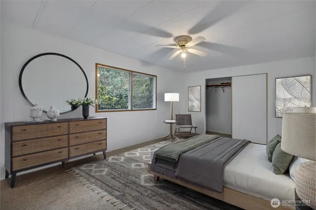 an empty room with closet and a ceiling fan