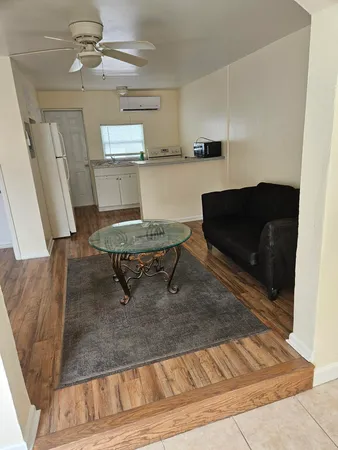 a living room with table chairs and wooden floor