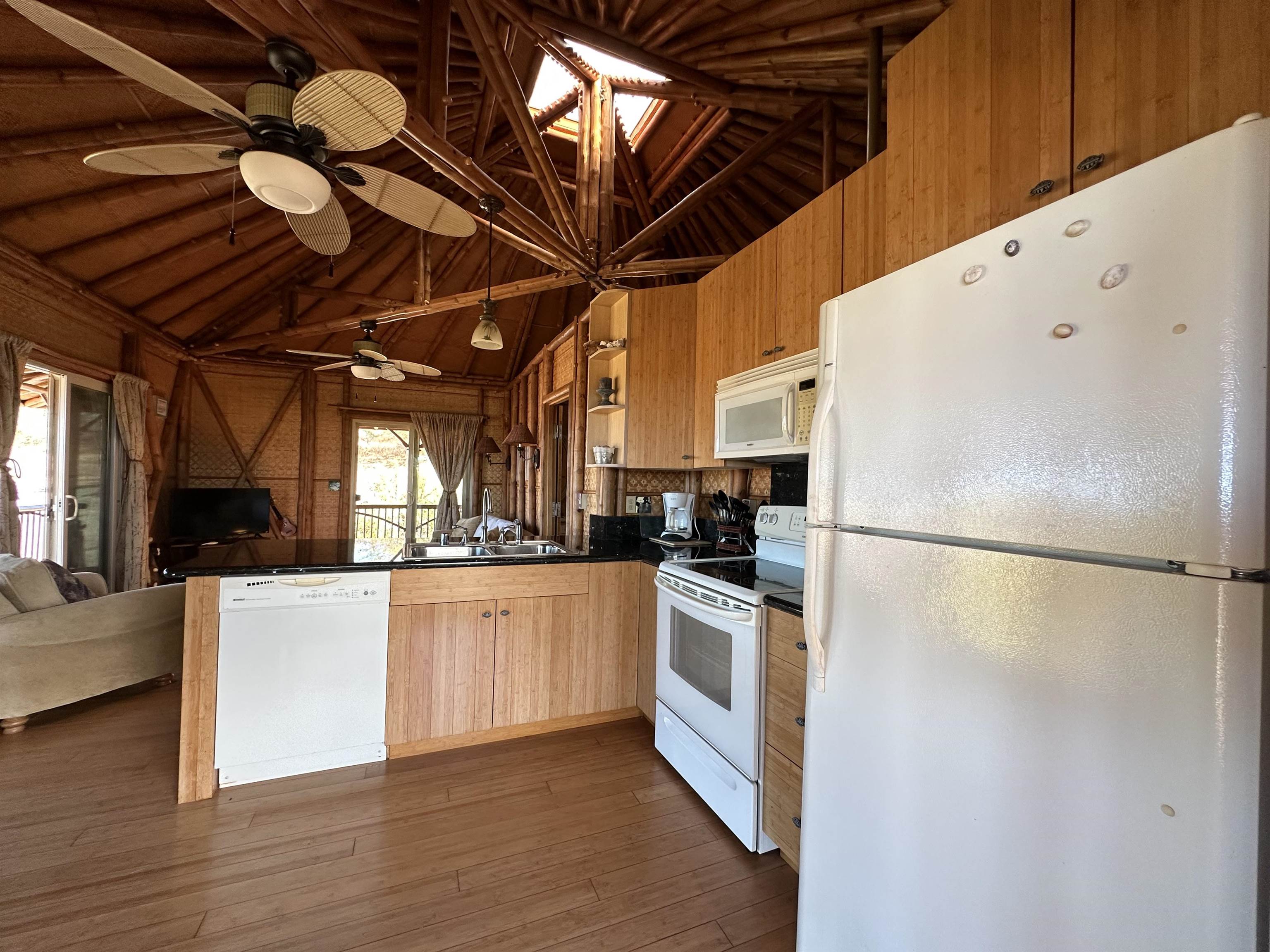 206 Awawa Road Maunaloa, HI 96770 - Photo 18 of 28 a kitchen with stainless steel appliances a refrigerator a stove a sink and white cabinets