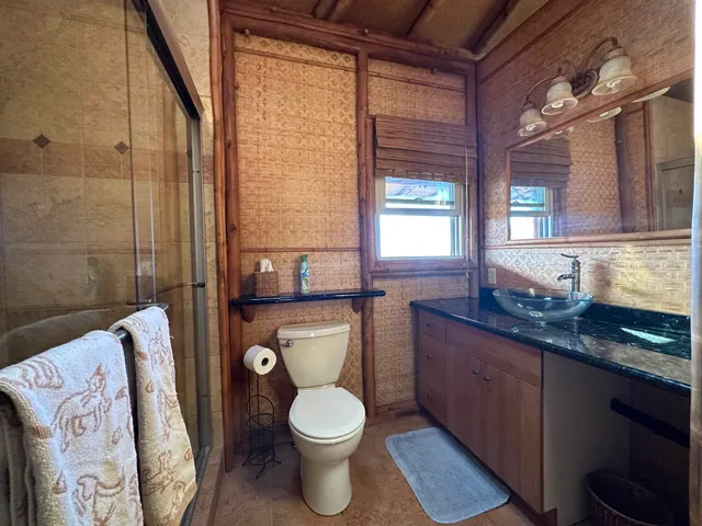 a bathroom with a granite countertop toilet sink and mirror