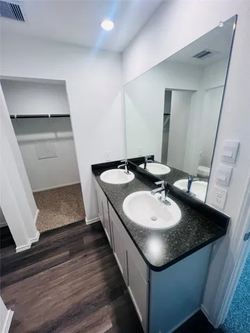 a bathroom with a granite countertop sink a mirror and vanity