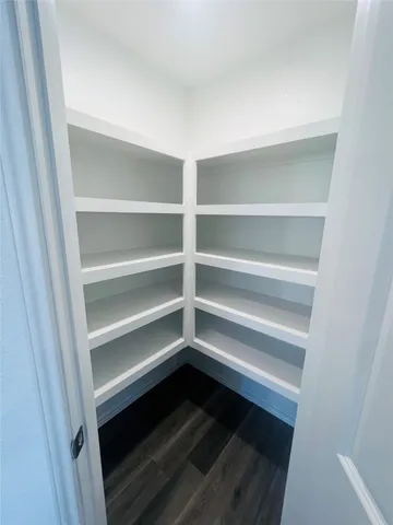 a view of walk in closet with empty racks
