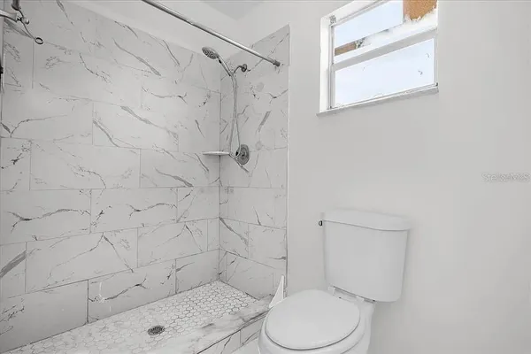 a white toilet sitting next to a shower