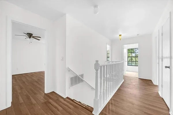 a view of a hallway with wooden floor and staircase