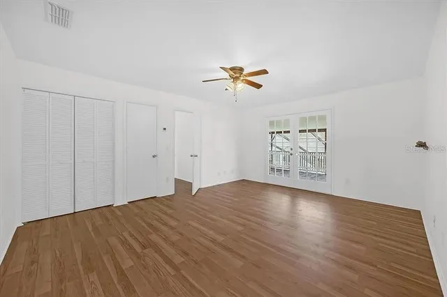 a view of empty room with wooden floor