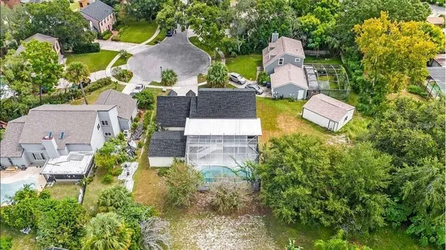 an aerial view of a house with a yard and a large tree