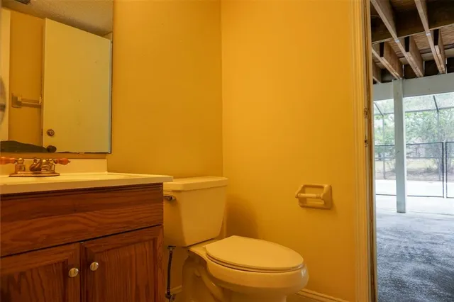 a bathroom with a granite countertop sink and a toilet