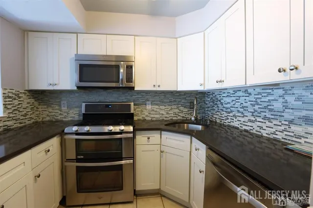 a kitchen with cabinets stainless steel appliances and a sink