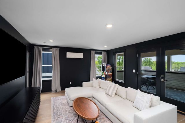 a living room with furniture a large window and kitchen view