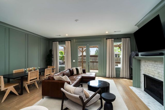 a living room with furniture a flat screen tv and a fireplace