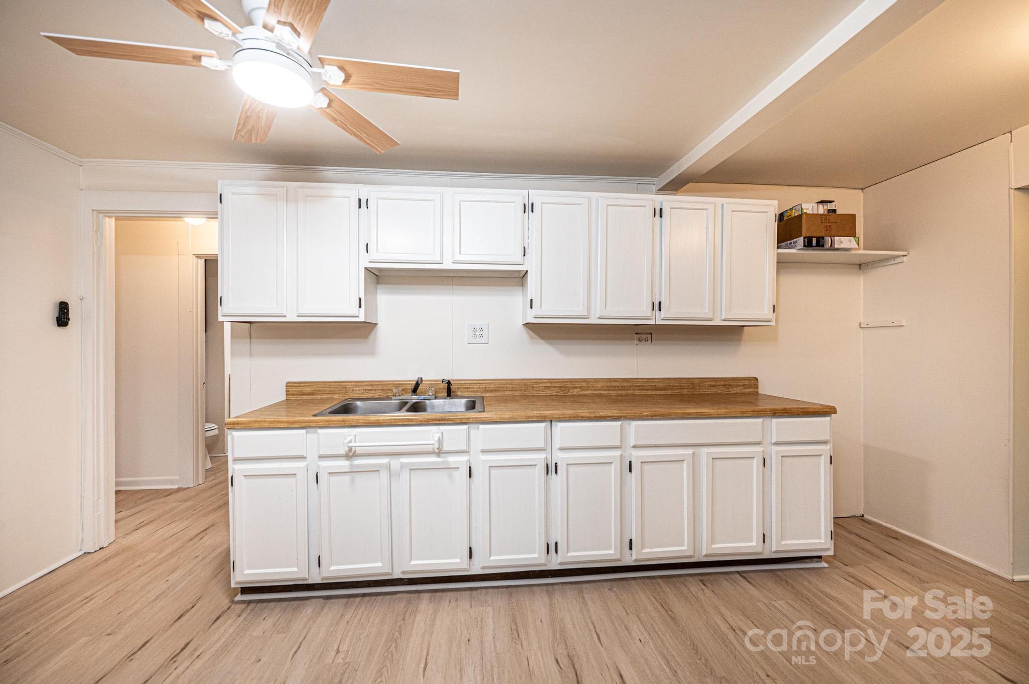 80 Duke Street Granite Falls, NC 28630 - Photo 30 of 48 a kitchen with stainless steel appliances granite countertop a stove a sink and white cabinets with wooden floor