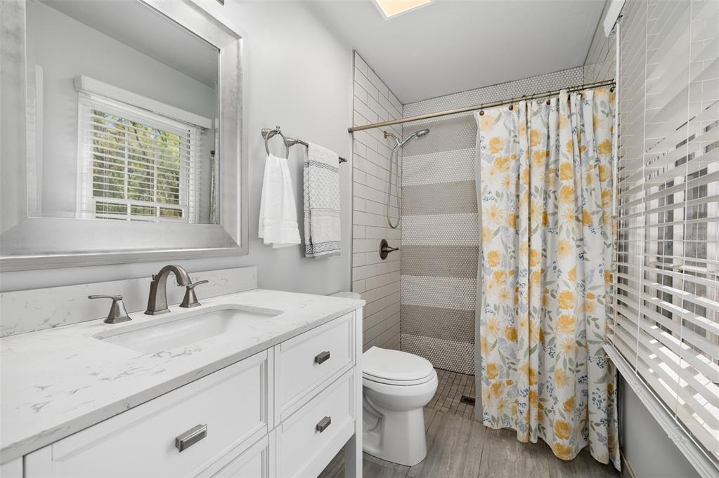 5326 Southwest 83 Terrace Gainesville, FL 32608 - Photo 21 of 40 a bathroom with a granite countertop sink a toilet and shower