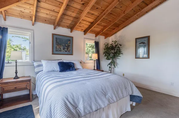 a bedroom with a large bed and a wooden floor