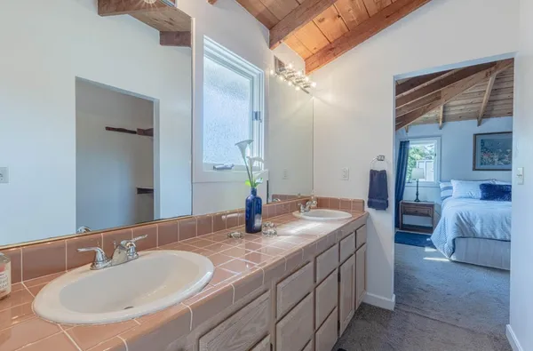 a en suite bathroom with a granite countertop sink and a mirror