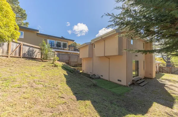 a view of a backyard with floor to ceiling window and wooden fence