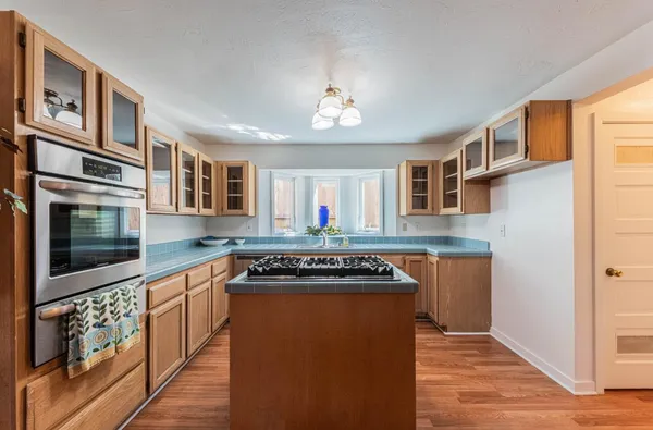 a kitchen with stainless steel appliances granite countertop a stove a sink and a microwave