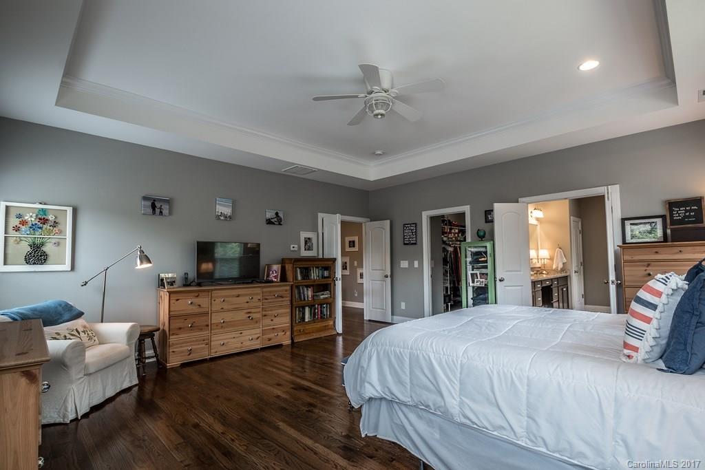 8037 Clems Branch Road, Unit 137 Indian Land, SC 29707 - Photo 13 of 24 a spacious bedroom with a bed and wooden floor