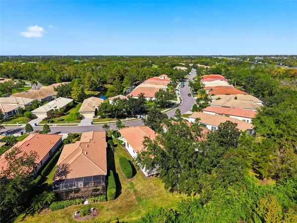 an aerial view of residential houses with outdoor space and trees