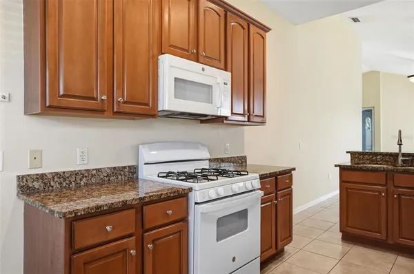 a kitchen with granite countertop cabinets and steel stove