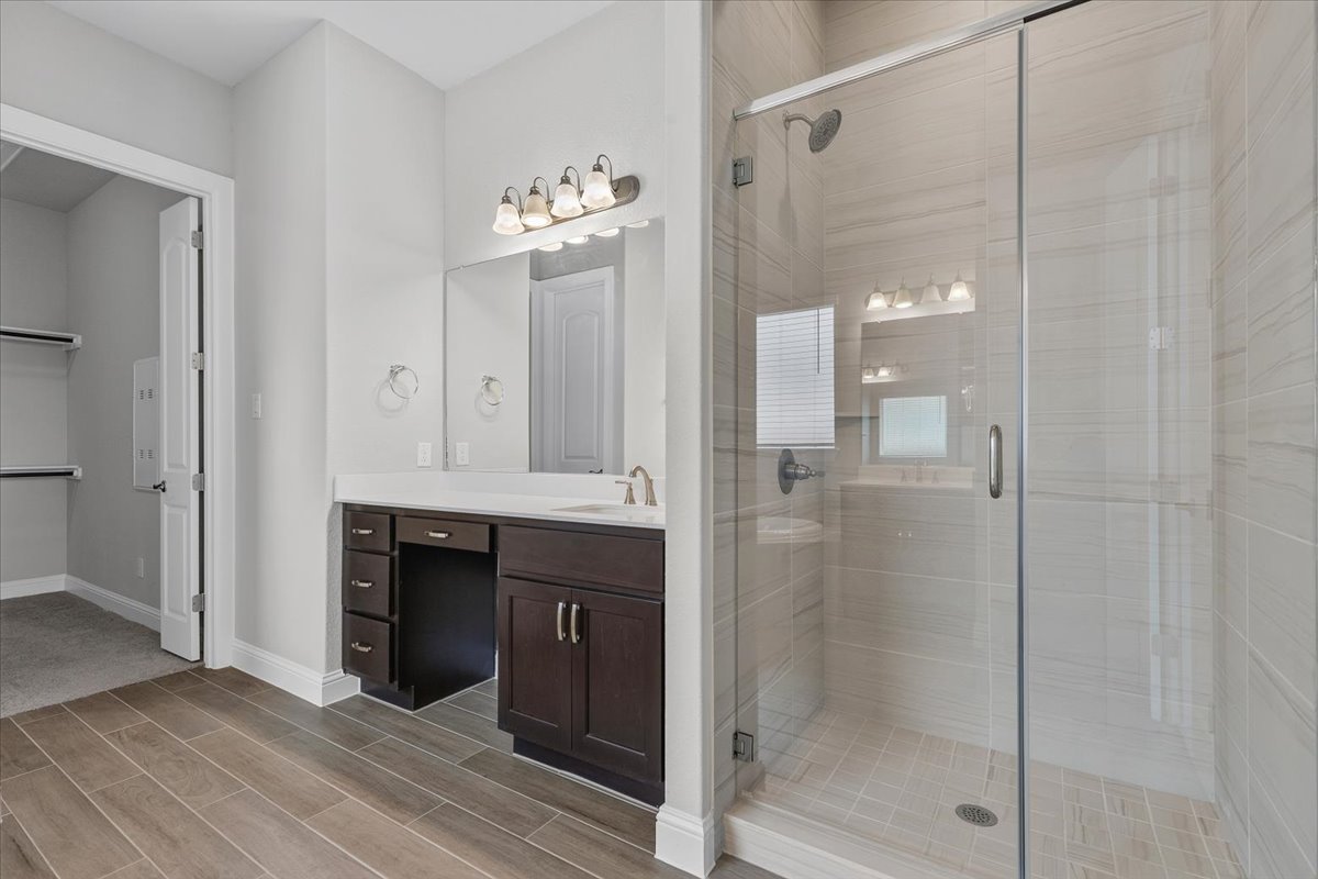 109 Rocky River Road Georgetown, TX 78628 - Photo 20 of 37 A well-appointed bath features rich cabinetry, a spacious vanity, and a clear glass shower enclosure.
