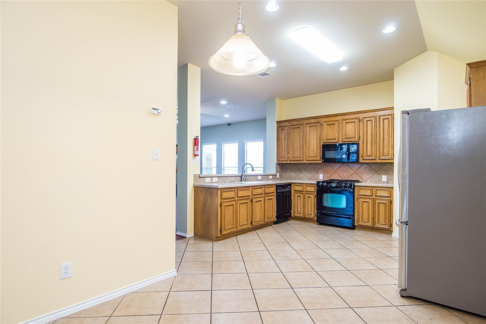 8847 Distant Woods Drive Houston, TX 77095 - Photo 17 of 26 a kitchen with stainless steel appliances a sink and a refrigerator
