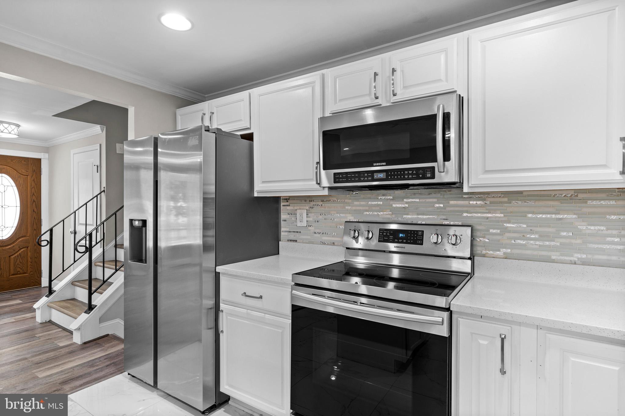 5908 Michael Road Waldorf, MD 20601 - Photo 14 of 44 a kitchen with stainless steel appliances a stove microwave and refrigerator