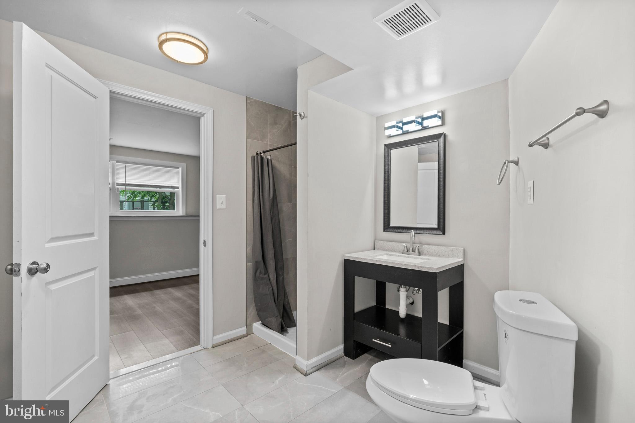 5908 Michael Road Waldorf, MD 20601 - Photo 36 of 44 a bathroom with a toilet a sink and mirror