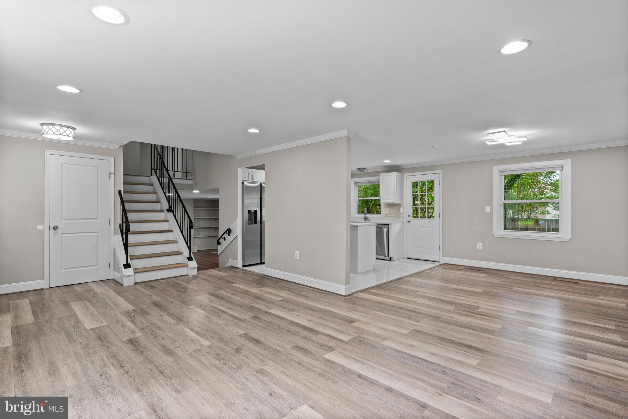 5908 Michael Road Waldorf, MD 20601 - Photo 9 of 44 an empty room with wooden floor staircase and windows