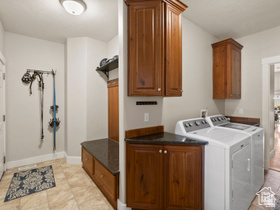514 North Olympic Way Midway, UT 84049 - Photo 22 of 30 Dedicated laundry area featuring a built-in bench with storage, dark wood-finish cabinetry, and a dark stone-finish countertop