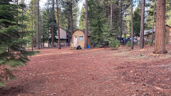 a view of a house with a yard and large trees