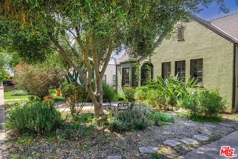 a front view of a house with a garden