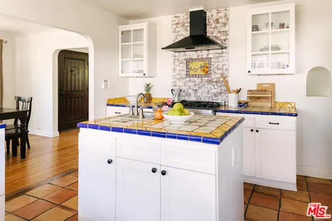 a kitchen with kitchen island granite countertop a sink cabinets and window