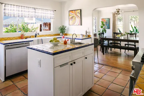 a kitchen with stainless steel appliances granite countertop a stove a sink and a dining table view