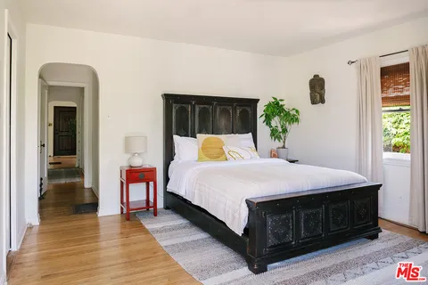 a bedroom with a bed and wooden floor