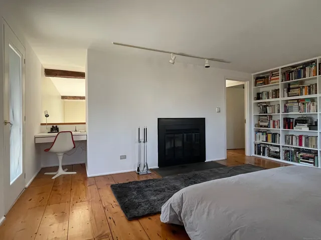 a spacious bedroom with a bed and a book shelf