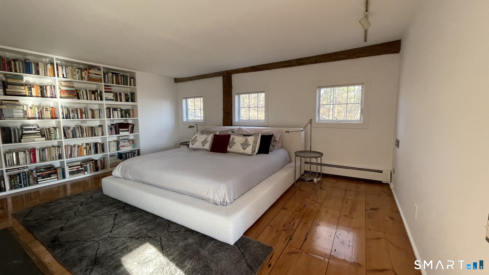 58 Wells Hill Road Weston, CT 06883 - Photo 19 of 38 a bedroom with a bed and a book shelf