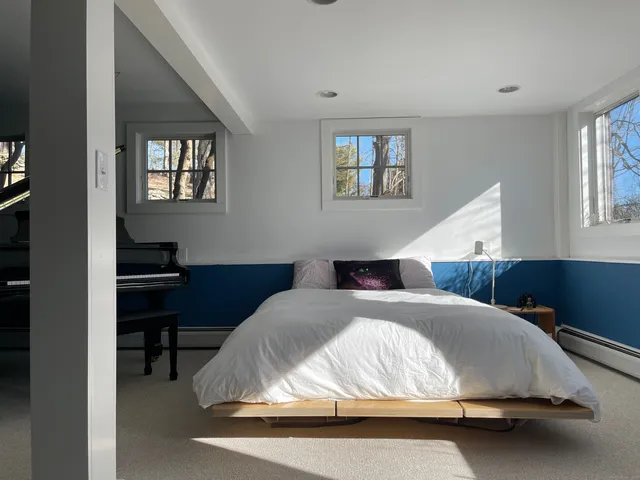 a bedroom with a bed a table and painting