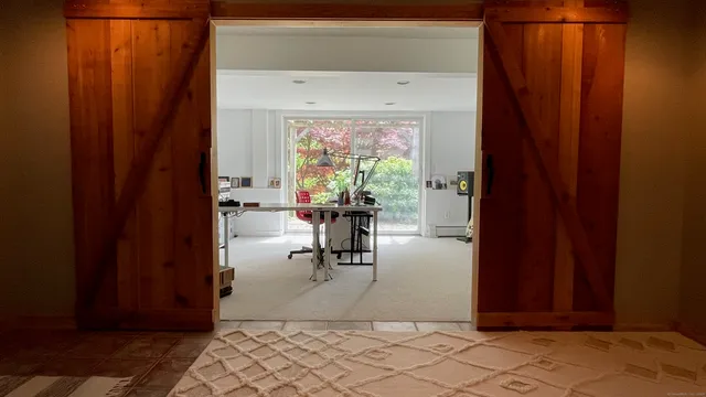 a view of a workspace with furniture and a window