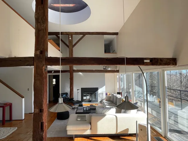 a living room with couches and a fireplace with wooden floor
