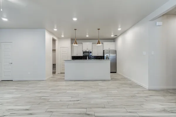 a view of a kitchen with kitchen island microwave and cabinets